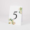 Numery stołów weselnych z bukietem białych kwiatów